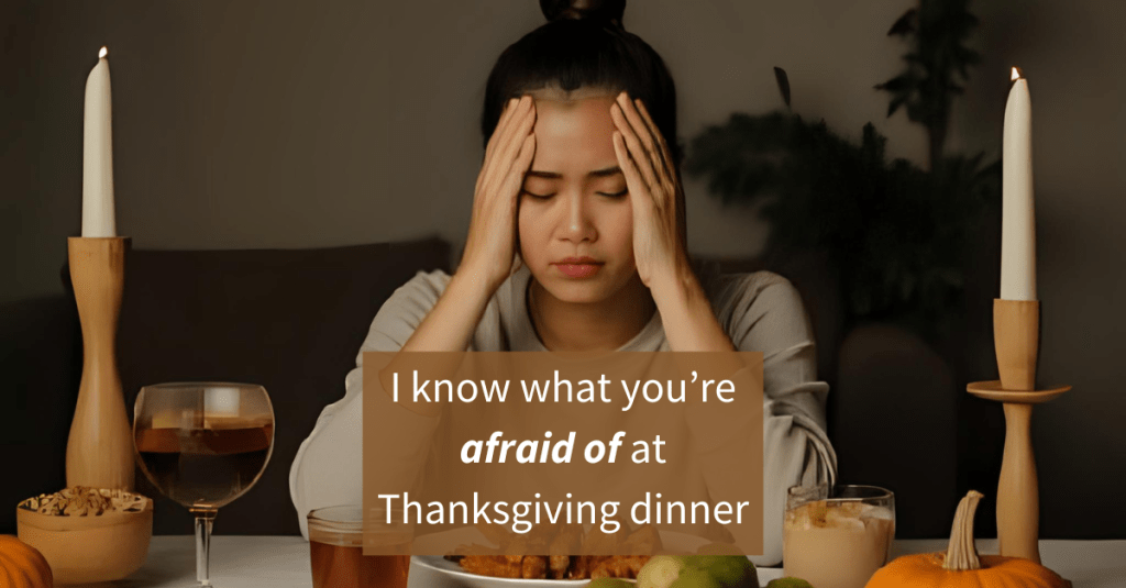 A woman sitting at a Thanksgiving table with her head in her hands, looking overwhelmed and anxious, surrounded by candles, drinks, and holiday foods.